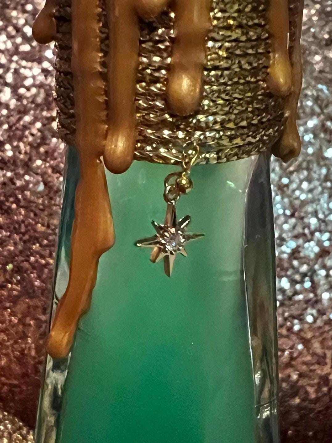 Wicked potion detail with gold wax drips and gold charm.