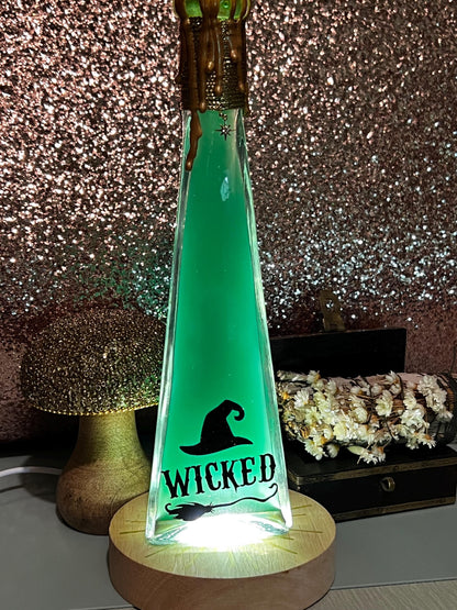 Wicked themed potion. Green dye with gold mica swirls. On a light up base to make a nightlight.